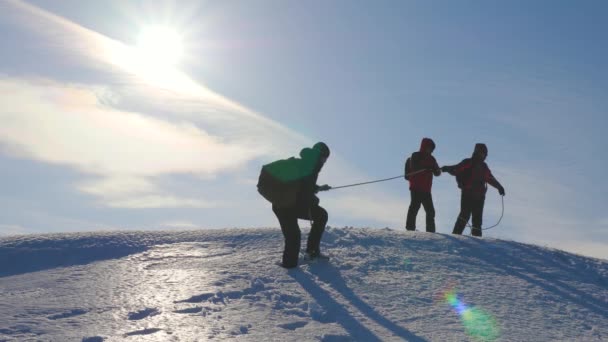 Equipe de alpinistas no inverno para baixo corda da montanha. turismo de trabalho em equipe bem coordenado no inverno. Os viajantes descem pela corda da colina nevada . — Vídeo de Stock