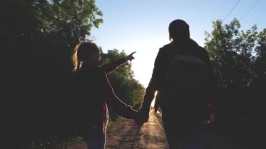 Hiker kız. Genç kızlar seyahat ve eller tutun. Çocuk yolcuları. sırt çantaları olan kızlar güneşin içinde ülke yolunda. Spor turizmi ve seyahat konsepti.