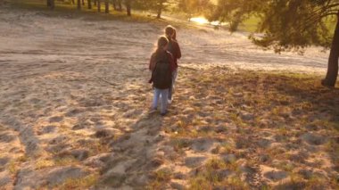 Kızlar sırt çantalarıyla ormanda seyahat eder. Yürüyüşçü Kız. aile ormanda yürür. Kızlar seyahat, orman üzerinden gidin. Tatil seyahatlerinde mutlu bir aile. spor turizmi konsepti.