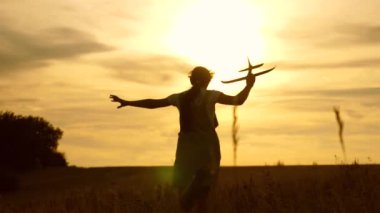 genç kız slint ışınları sahada bir oyuncak uçak ile çalışır. çocuklar oyuncak uçak oynarlar. uçan ve bir pilot olma genç hayalleri. kız bir pilot ve astronot olmak istiyor.