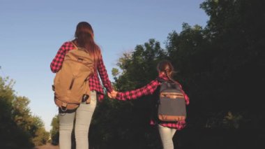 Genç kızlar seyahat ve eller tutun. Hiker kız. Çocuk yolcuları. sırt çantaları olan kızlar güneşin içinde ülke yolunda. Spor turizmi ve seyahat konsepti.