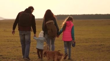 Aile, ovada köpek ile seyahat eder. yakın örme bir ailenin takım çalışması. Anne, küçük çocuk ve kızları ve evcil turistler. Doğada spor aile tatili kavramı.