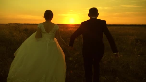 Pár szerelmes egy nászút utazás. Menyasszony és a vőlegény. Lassított. Boldog ember és nő fut napnyugtakor. — Stock videók