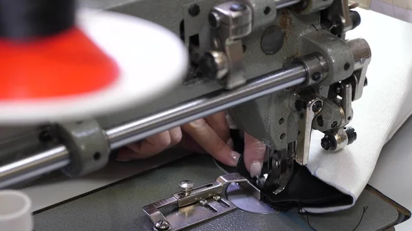 ミシンの針はすぐに上下に動きます。革製品を縫うプロセス。テーラーは縫製ワークショップで黒い革を縫います。動いているミシンの針、クローズアップ. — ストック写真