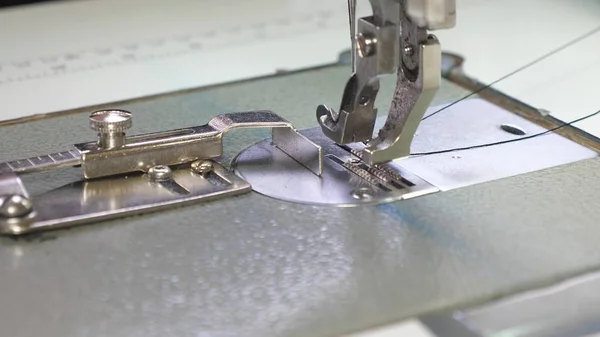 Die Nadel der Nähmaschine bewegt sich schnell auf und ab. Prozess des Nähens von Lederwaren. Schneider näht schwarzes Leder in Nähwerkstatt. Nadel der Nähmaschine in Bewegung, Nahaufnahme. — Stockfoto