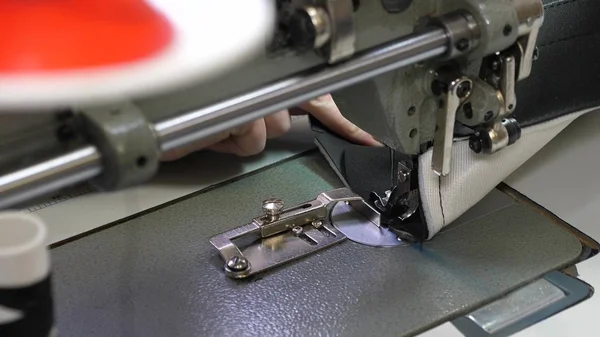 Aguja de la máquina de coser se mueve rápidamente hacia arriba y hacia abajo. proceso de coser artículos de cuero. Sastre cose cuero negro en taller de costura. aguja de la máquina de coser en movimiento, primer plano . — Foto de Stock