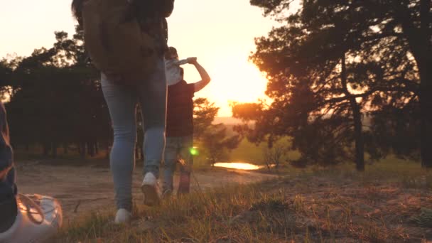 Familia feliz con un niño pequeño viajando por el bosque. Papá mamá e hijas viajeros. Hiker Girl. Trabajo en equipo de niños y padres. Una familia feliz de vacaciones. concepto de turismo deportivo . — Vídeos de Stock