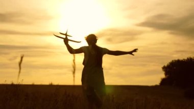 genç kız slint ışınları sahada bir oyuncak uçak ile çalışır. çocuklar oyuncak uçak oynarlar. uçan ve bir pilot olma genç hayalleri. kız bir pilot ve astronot olmak istiyor.