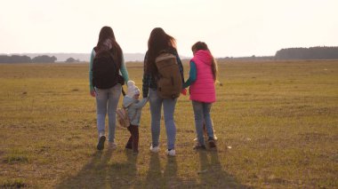 Sırt çantaları olan aile bir köpekle seyahat ediyor. yakın örme bir ailenin takım çalışması. Anne, kızları ve ev Evcil turistler. doğada bir spor aile tatil kavramı.