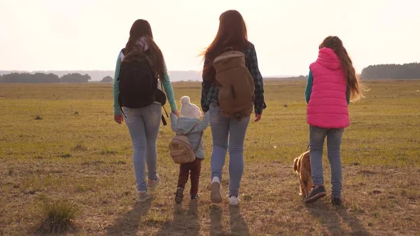 Familie mit Rucksack reist mit Hund. Teamwork einer engen Familie. Mutter, Töchter und Haustiere Touristen. Konzept eines sportlichen Familienurlaubs in der Natur. — Stockfoto