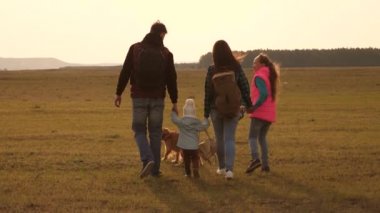 Aile, ovada köpek ile seyahat eder. yakın örme bir ailenin takım çalışması. Anne, küçük çocuk ve kızları ve evcil turistler. Doğada spor aile tatili kavramı.