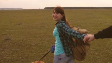 Genç çift el tutarak seyahat ediyorlar. Benden sonra gel. turistler bir takımda çalışmak. aşık eller gün batımında seyahat vardır. sırt çantası ile mutlu kadın elinde adam tutar ve onu yol.