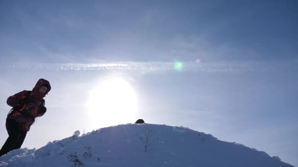 Teamwerk en overwinning. Toeristen komen naar top van besneeuwde heuvel en zich verheugen op overwinning tegen de achtergrond van een gele zonsondergang. teamwork van mensen in moeilijke omstandigheden. — Stockvideo