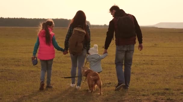 Семья путешествует с собакой на равнине. Командная работа сплоченной семьи. мать, маленький ребенок и дочери и домашние животные туристов. Концепция спортивного семейного отдыха на природе . — стоковое видео