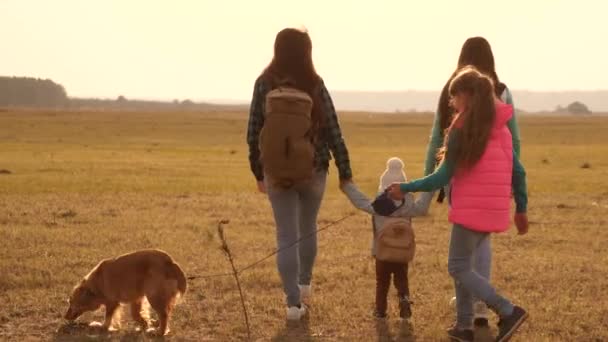 Sırt çantaları olan aile bir köpekle seyahat ediyor. yakın örme bir ailenin takım çalışması. Anne, kızları ve ev Evcil turistler. doğada bir spor aile tatil kavramı. — Stok video