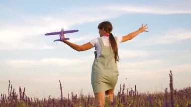 Mutlu kız bir çiçek alanında bir oyuncak uçak ile çalışır. çocuklar oyuncak uçak oynarlar. uçan ve bir pilot olma genç hayalleri. kız bir pilot ve astronot olmak istiyor.