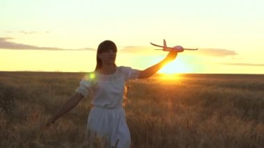 Mutlu kız bir çiçek alanında bir oyuncak uçak ile çalışır. çocuklar oyuncak uçak oynarlar. uçan ve bir pilot olma genç hayalleri. kız bir pilot ve astronot olmak istiyor.