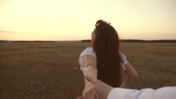 Lycklig i kärlek par går hand i hand. flickan springer över fältet som håller handen på sin älskade man och skrattar. Slow motion. konceptet med en lycklig familj. flicka och man reser utanför staden. — Stockvideo