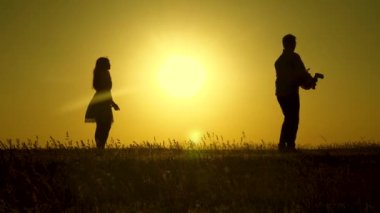 baba ve anne güneşin parlak ışınları kızı ile oynamak. Ebeveynler küçük kızları ile oynarlar. mutlu bebek babadan anneye geçer. genç aile alanında bir çocuk 1 yıl. aile mutluluğu kavramı.