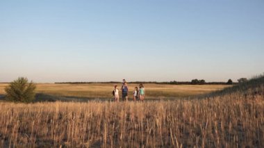 Baba anne ve kızları kampa gidiyor. Seyahat eden turist ailesi. sırt çantaları ile çocuk ve baba ve anne vadi yoluyla seyahat. turistlerin takım çalışması. zafere hareket.