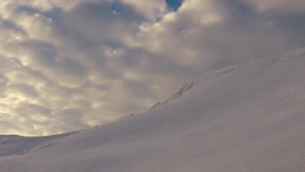 Beautiful blue sky at sunset, high in the sky flying pink clouds illuminated by the sun. landscape snowy peak and red clouds. dawn or sunrise over a snowy mountain. — Stock Video