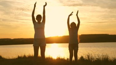 Sahilde dans eden mutlu kızlar. göl kenarında parti, çocuklar dans. müzik dinlerken eğlenceli güzel kızlar. Kız kardeşler dans ediyor. gençler kız tatil disko.