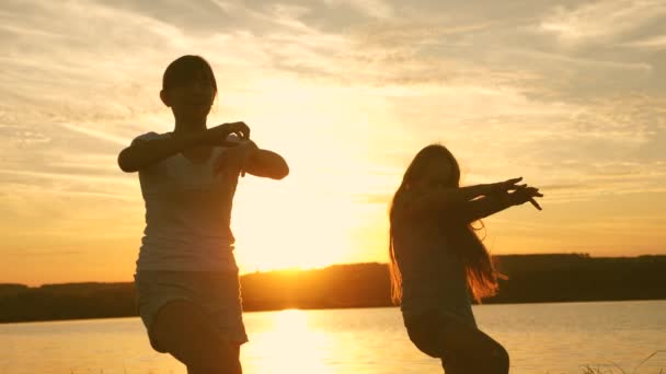 Wiek dojrzewania dziewczyny wakacje Disco. Impreza nad jeziorem, dzieci tańczą. szczęśliwe dziewczyny tańczą na plaży. piękne dziewczyny zabawy słuchania muzyki. siostry tańczą. — Wideo stockowe