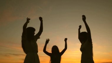 Sahilde dans eden mutlu kızlar. göl kenarında parti, çocuklar dans. Yavaş çekim. müzik dinlerken eğlenceli güzel kızlar. Kız kardeşler dans ediyor. gençler kız tatil disko.