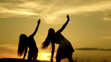 Sahilde dans eden mutlu kızlar. göl kenarında parti, çocuklar dans. müzik dinlerken eğlenceli güzel kızlar. Kız kardeşler dans ediyor. gençler kız tatil disko.