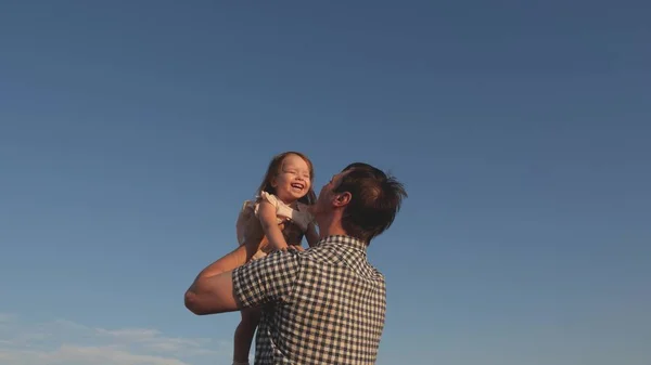 Ο μπαμπάς ξερνάει μια ευτυχισμένη κόρη στον γαλάζιο ουρανό. Πατέρας και μικρό παιδί παίζουν, γελάνε και αγκαλιάζονται μαζί. Ευτυχισμένα οικογενειακά ταξίδια. Το μωρό στην αγκαλιά του γονέα. Ο μπαμπάς έχει ρεπό. Η έννοια της ευτυχισμένης οικογένειας. — Φωτογραφία Αρχείου