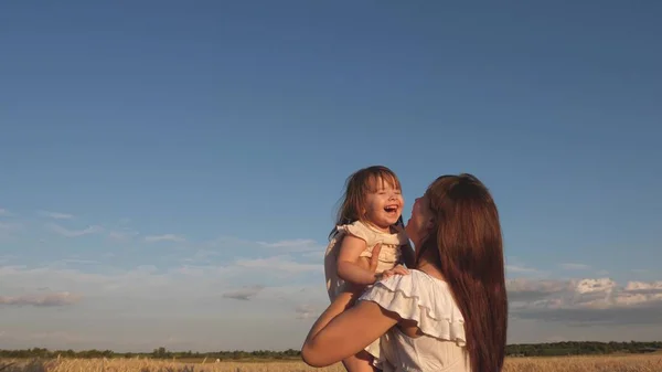 Matka a malá holčička hrají na poli zralých pšenice. šťastné rodinné cesty. Máma hází šťastnou dceru na oblohu. dítě v náručí matky. šťastný rodinný koncept. — Stock fotografie
