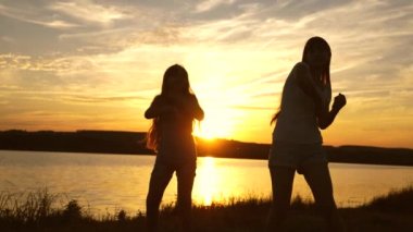 gençler kız tatil disko. göl kenarında parti, çocuklar dans. Sahilde dans eden mutlu kızlar. müzik dinlerken eğlenceli güzel kızlar. kız kardeşler dans ediyor.