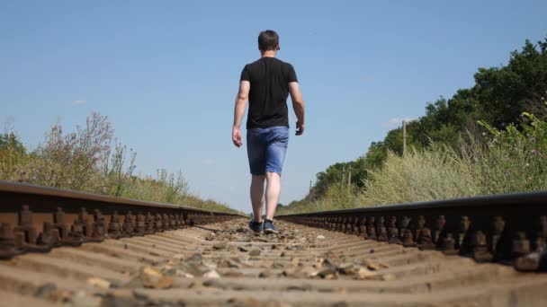 El viajero camina en los lazos del ferrocarril. pasos turísticos en los durmientes. el pasajero se quedó atrás del tren . — Vídeos de Stock