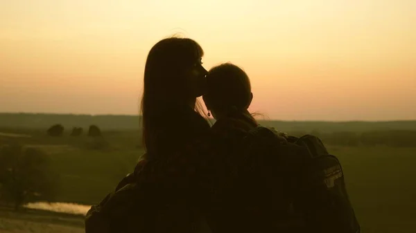 Kvinna resenärer mamma och dotter kram och njuta av sin seger och njuta av solnedgången. Hiker flicka. Teamwork resenärer med ryggsäckar. Familj av turister på semester. Resor Njut av landskapet vid solnedgången. — Stockfoto