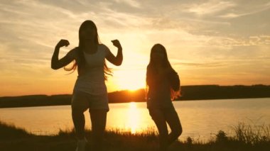 gençler kız tatil disko. göl kenarında parti, çocuklar dans. Sahilde dans eden mutlu kızlar. müzik dinlerken eğlenceli güzel kızlar. kız kardeşler dans ediyor.