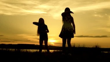 Sahilde dans eden mutlu kızlar. göl kenarında parti, çocuklar dans. müzik dinlerken eğlenceli güzel kızlar. Kız kardeşler dans ediyor. gençler kız tatil disko.