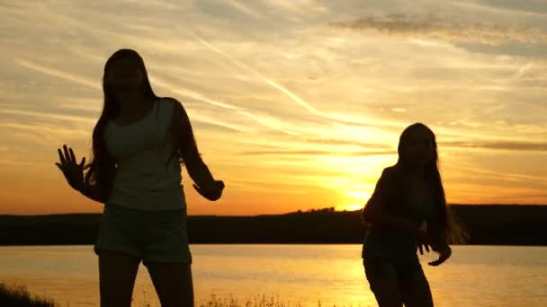 Adolescence copines vacances disco. fête au bord du lac, les enfants dansent. filles heureuses dansant sur la plage. belles filles s'amusent à écouter de la musique. sœurs dansent . — Video