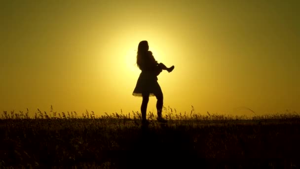 Mom plays with her daughter in sunshine. parents play with little daughter. happy child walks with his mother in park at sunset. family in field with a 1 year old baby. concept of family happiness. — Stock Video