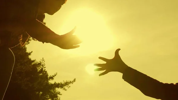 Le ragazze viaggiatrici si aiutano a vicenda a conquistare la cima di un'alta montagna, tenendosi per mano e tirandosi l'un l'altro in cima al tramonto. Ragazza escursionista. turismo familiare. Escursioni estreme per coraggiosi. viaggiatori di lavoro di squadra . — Foto Stock