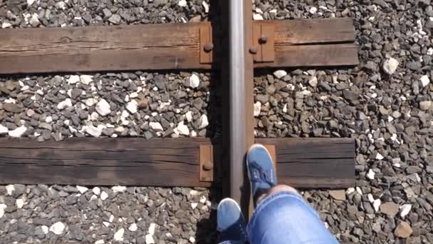 Legs of a traveler go on rails on the railway. close-up. tourist steps on the sleepers. the passenger lagged behind the train. Slow motion — Stock Video