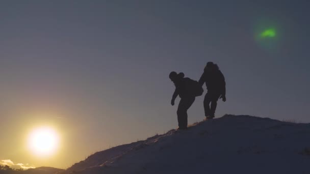 Lagarbete klättrare vänner i bergen. resenärer härstammar från ett högt snöigt berg och letar efter äventyr i strålande solsken på vintern. begreppet turister erövrar berget. — Stockvideo
