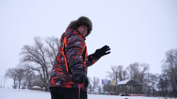 幸せな旅行者は冬とそりで遊びます。リゾートでの冬の観光。冬の雪の日にそりで楽しんでいる若い家族。人々は雪の受け皿に乗る。クローズ アップ。クリスマス. — ストック動画