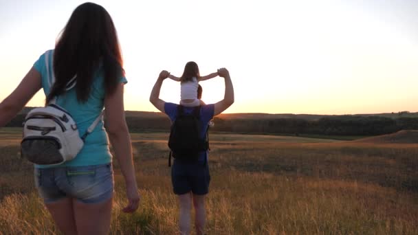 Père porte une petite fille sur ses épaules, une famille heureuse voyage dans le parc. Famille avec enfants voyage dans les plaines et les montagnes. père, mère fille touristes. travail d'équipe voyageurs . — Video