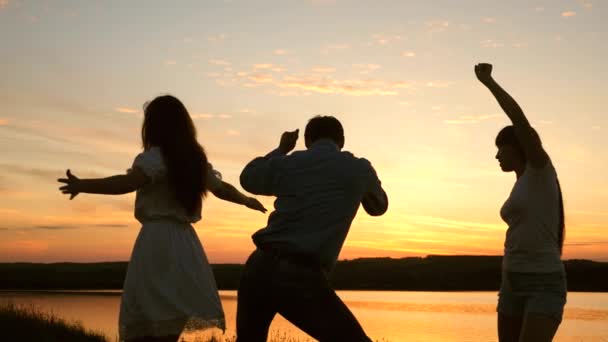 Feliz familia bailando en la playa. fiesta junto al lago, niños bailando. chicas felices bailando en la playa. En cámara lenta. hermosas chicas divirtiéndose escuchando música. adolescentes novias fiesta disco . — Vídeo de stock