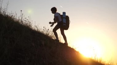 sırt çantaları olan çocuklar güneşte bir dağa tırmanma seyahat. Kız kampa gidiyor. Gün batımında seyahat eden çocuklu turist ailesi. turistlerin ortak çalışma. zafere hareket. Yavaş çekim .hiker