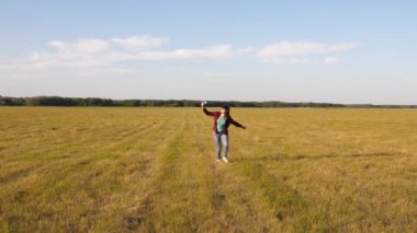 uçan ve pilot olma genç hayalleri. Mutlu kız gün batımı ışığında bir alanda bir oyuncak uçak ile çalışır. çocuklar oyuncak uçak oynarlar. kız pilot ve astronot olmak istiyor. Yavaş çekim