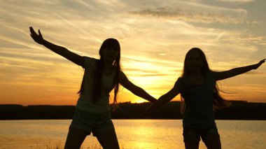 gençler kız tatil disko. göl kenarında parti, çocuklar dans. Sahilde dans eden mutlu kızlar. müzik dinlerken eğlenceli güzel kızlar. kız kardeşler dans ediyor.