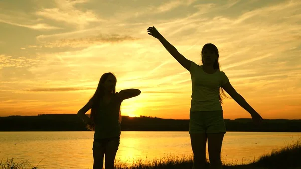 Adolescentes novias disco de vacaciones. fiesta junto al lago, niños bailando. chicas felices bailando en la playa. hermosas chicas divirtiéndose escuchando música. hermanas están bailando . —  Fotos de Stock