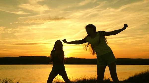 Adolescence copines vacances disco. fête au bord du lac, les enfants dansent. filles heureuses dansant sur la plage. belles filles s'amusent à écouter de la musique. sœurs dansent . — Photo