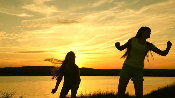 Adolescence copines vacances disco. fête au bord du lac, les enfants dansent. filles heureuses dansant sur la plage. belles filles s'amusent à écouter de la musique. sœurs dansent . — Photo